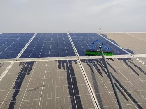 Professionelle Reinigung einer Photovoltaikanlage mit Teleskopstange und Reinwasserbürste
